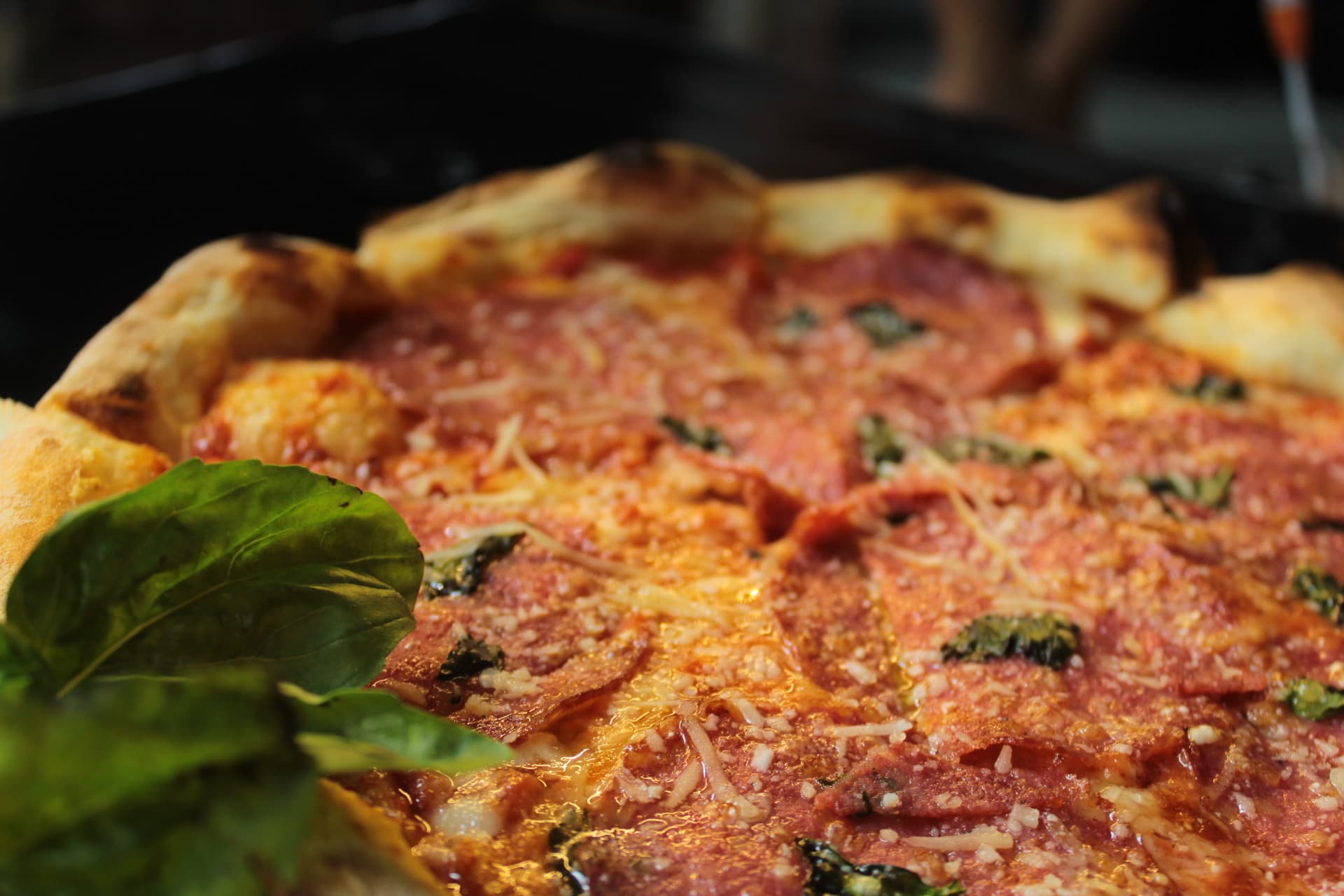Close-up of wood-fired pizza crust and tomato